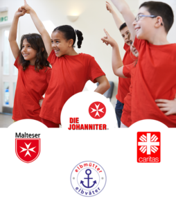 Tanzende Kinder mit roten T-Shirts. Darunter platziert sind diese Logos: Malteser, Die Johanniter, Caritas, Elbmütter.